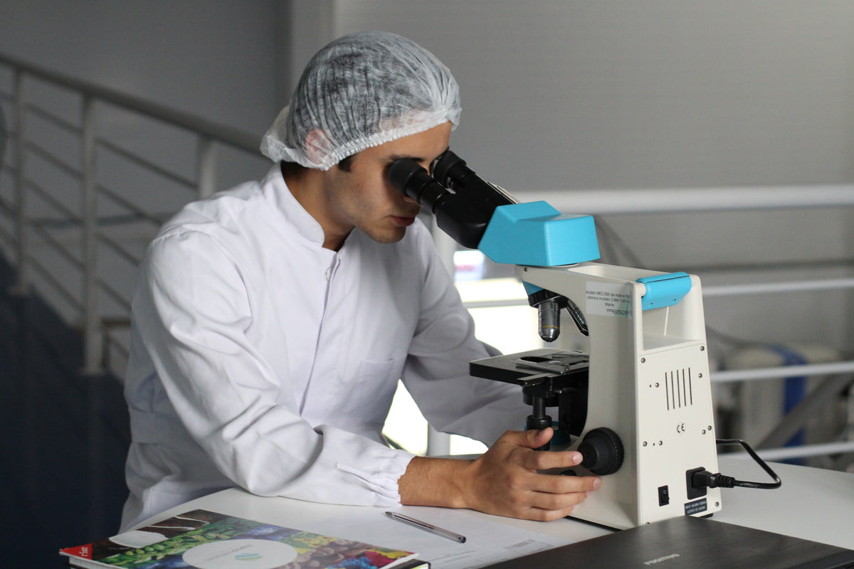 Engineer using microscopy and test equipment during iterative medical device development